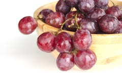 Groupes juteux d'isolement de grands raisins rouges lovés d'une cuvette en bois image libre de droits Groupes juteux d'isolement de grands raisins rouges lovés d'une cuvette en bois image libre de droits