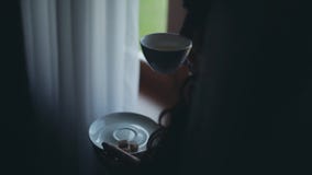 Großaufnahme der Brunettefrau untersuchend den Abstand und den trinkenden Tee Weiblicher Ausgabenmorgen zu Hause allein stock video Großaufnahme der Brunettefrau untersuchend den Abstand und den trinkenden Tee Weiblicher Ausgabenmorgen zu Hause allein stock video