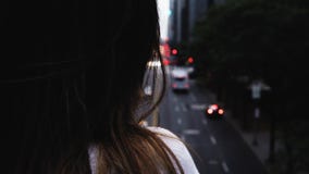 Großaufnahme der weiblichen Stellung des jungen Brunette auf der Brücke und des Schauens auf der Verkehrsstraße in New York, Amer stock footage Großaufnahme der weiblichen Stellung des jungen Brunette auf der Brücke und des Schauens auf der Verkehrsstraße in New York, Amer stock footage