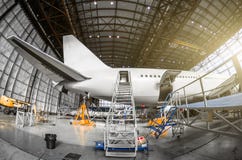 Große Passagierflugzeuge auf Service in einer hinteren Ansicht des Luftfahrthangar des Endstücks, Passageleitereingang lizenzfreies stockbild Große Passagierflugzeuge auf Service in einer hinteren Ansicht des Luftfahrthangar des Endstücks, Passageleitereingang lizenzfreies stockbild