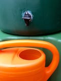 Großer grüner Wasserkolben für Regenwasser mit Gießkanne lizenzfreie stockbilder Großer grüner Wasserkolben für Regenwasser mit Gießkanne lizenzfreie stockbilder