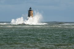 Großer Wellen-Einfassungs-Stein-Leuchtturm als Sun-Brüche durch in M stockfotos Großer Wellen-Einfassungs-Stein-Leuchtturm als Sun-Brüche durch in M stockfotos
