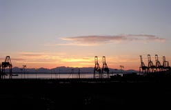 Gru a cavalletto del carico su lungomare di Seattle al tramonto immagini stock libere da diritti Gru a cavalletto del carico su lungomare di Seattle al tramonto immagini stock libere da diritti
