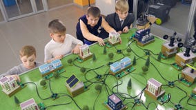 Grundschüler, die Projekt der alternativen Energie der Studie auf einem Stadtprototyp tun stock video footage Grundschüler, die Projekt der alternativen Energie der Studie auf einem Stadtprototyp tun stock video footage