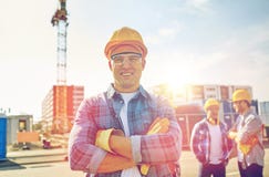 Grupa uśmiechnięci budowniczowie w hardhats outdoors obrazy stock Grupa uśmiechnięci budowniczowie w hardhats outdoors obrazy stock