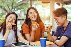 Grupo asiático que come junto a pizza em quebrar o tempo fotografia de stock royalty free Grupo asiático que come junto a pizza em quebrar o tempo fotografia de stock royalty free