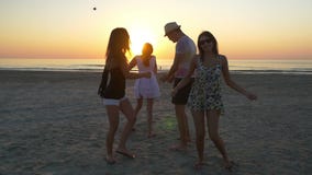 Grupo de adolescentes jovenes que bailan en una playa en la salida del sol almacen de metraje de vídeo Grupo de adolescentes jovenes que bailan en una playa en la salida del sol almacen de metraje de vídeo