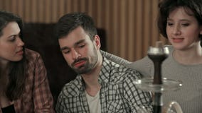 Grupo de amigos jovenes que se relajan en club-barra del shisha almacen de metraje de vídeo Grupo de amigos jovenes que se relajan en club-barra del shisha almacen de metraje de vídeo