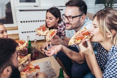 Grupo de amigos novos que comem a pizza imagem de stock royalty free Grupo de amigos novos que comem a pizza imagem de stock royalty free