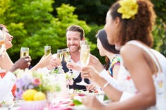 Grupo de amigos que apreciam o partido de jantar exterior imagem de stock Grupo de amigos que apreciam o partido de jantar exterior imagem de stock