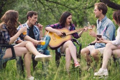 Grupo de amigos que se sientan en círculo hacia fuera en parque imagen de archivo libre de regalías Grupo de amigos que se sientan en círculo hacia fuera en parque imagen de archivo libre de regalías
