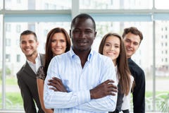 Grupo de empresarios amistosos con el líder de sexo masculino en frente imagen de archivo Grupo de empresarios amistosos con el líder de sexo masculino en frente imagen de archivo