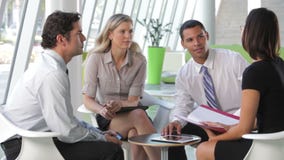 Grupo de executivos que têm a reunião informal video estoque Grupo de executivos que têm a reunião informal video estoque