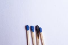 Grupo de 4 fósforos e de um fósforo queimado foto de stock Grupo de 4 fósforos e de um fósforo queimado foto de stock