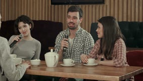 Grupo de gente joven que canta en el micrófono en el partido en club del Karaoke almacen de metraje de vídeo Grupo de gente joven que canta en el micrófono en el partido en club del Karaoke almacen de metraje de vídeo