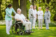 Grupo de pacientes e de enfermeiras no lar de idosos imagem de stock Grupo de pacientes e de enfermeiras no lar de idosos imagem de stock