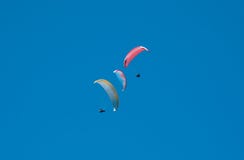 Grupo de paragliders que voam no céu azul na perspectiva das nuvens Parapente no céu em um dia ensolarado fotografia de stock Grupo de paragliders que voam no céu azul na perspectiva das nuvens Parapente no céu em um dia ensolarado fotografia de stock