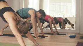 Grupo de personas que hace asanas de la yoga en estudio Grupo de personas que hace asanas de la yoga en estudio