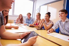 Grupp av högskolestudenter som sitter på tabellen som har diskussion royaltyfria foton Grupp av högskolestudenter som sitter på tabellen som har diskussion royaltyfria foton