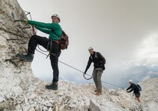 Grupp av unga bergsbestigare på ett brant via Ferrata med en storstilad sikt av de italienska dolomitesna arkivfoton Grupp av unga bergsbestigare på ett brant via Ferrata med en storstilad sikt av de italienska dolomitesna arkivfoton