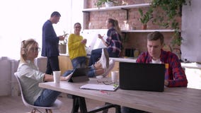 Gruppe erfolgreiche junge Büroangestellte sind, arbeitend essend und mit Tabletten und Laptops in der Küche während der Schaffung stock footage Gruppe erfolgreiche junge Büroangestellte sind, arbeitend essend und mit Tabletten und Laptops in der Küche während der Schaffung stock footage