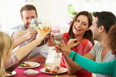 Gruppe Freunde, die Toast um Tabelle am Abendessen machen Gruppe Freunde, die Toast um Tabelle am Abendessen machen