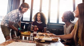 Gruppe Freunde am Pizzarestaurant lizenzfreies stockbild Gruppe Freunde am Pizzarestaurant lizenzfreies stockbild
