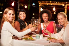 Gruppe Freundinnen, die Abendessen am Dachspitzenrestaurant essen lizenzfreie stockfotografie Gruppe Freundinnen, die Abendessen am Dachspitzenrestaurant essen lizenzfreie stockfotografie