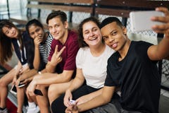 Gruppe junge Jugendlichfreunde auf einem Basketballplatz, der ein selfie nehmend sich entspannt lizenzfreies stockbild Gruppe junge Jugendlichfreunde auf einem Basketballplatz, der ein selfie nehmend sich entspannt lizenzfreies stockbild