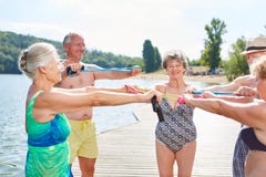 Gruppe Senioren am See tut Gymnastik lizenzfreies stockfoto Gruppe Senioren am See tut Gymnastik lizenzfreies stockfoto