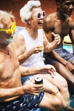 Gruppe verschiedene ältere Erwachsenen, die durch das Pool summ genießend sitzen Lizenzfreies Stockbild Gruppe verschiedene ältere Erwachsenen, die durch das Pool summ genießend sitzen Lizenzfreies Stockbild