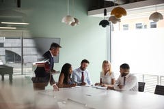 Gruppen-Sitzung um Tabelle am graduierten Einstellungs-Einschätzungs-Tag und Zusammenarbeiten auf Aufgabe, während, beobachtend d lizenzfreies stockbild Gruppen-Sitzung um Tabelle am graduierten Einstellungs-Einschätzungs-Tag und Zusammenarbeiten auf Aufgabe, während, beobachtend d lizenzfreies stockbild