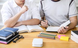 Gruppo dell'istitutore o dello studente di college della High School che si siede allo scrittorio in biblioteca che studia e che fotografia stock Gruppo dell'istitutore o dello studente di college della High School che si siede allo scrittorio in biblioteca che studia e che fotografia stock