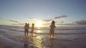 Gruppo di amici che corrono verso il mare sulla bella spiaggia all'alba video d archivio Gruppo di amici che corrono verso il mare sulla bella spiaggia all'alba video d archivio