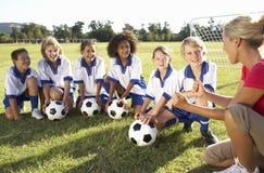 Gruppo di bambini nel Coa di Team Having Training With Female di calcio fotografia stock libera da diritti Gruppo di bambini nel Coa di Team Having Training With Female di calcio fotografia stock libera da diritti