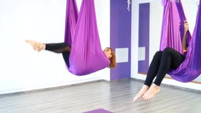 Gruppo di giovani donne che fanno pratica aerea di yoga in amaca porpora video d archivio Gruppo di giovani donne che fanno pratica aerea di yoga in amaca porpora video d archivio