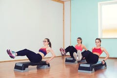 Gruppo di giovani donne di sport che risolvono con gli steppers in palestra immagini stock Gruppo di giovani donne di sport che risolvono con gli steppers in palestra immagini stock
