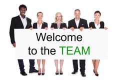 Gruppo di persone di affari che tengono benvenuto a Team Placard immagini stock Gruppo di persone di affari che tengono benvenuto a Team Placard immagini stock