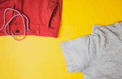 Grå tshirt och röda kortslutningar på gul bakgrund, sikt från överkant fotografering för bildbyråer Grå tshirt och röda kortslutningar på gul bakgrund, sikt från överkant fotografering för bildbyråer