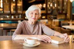 Gråhårig hög dam som kopplar av i kafé royaltyfria bilder Gråhårig hög dam som kopplar av i kafé royaltyfria bilder