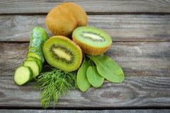 Gröna grönsaker och frukter: kiwi gurka, dill, syra på träbakgrund royaltyfri foto Gröna grönsaker och frukter: kiwi gurka, dill, syra på träbakgrund royaltyfri foto
