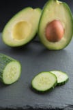 Gröna smoothieingredienser - avokado, gurka på en mörk bakgrund arkivbilder Gröna smoothieingredienser - avokado, gurka på en mörk bakgrund arkivbilder
