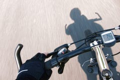 Guante de la mano del ciclista en el manillar de la bicicleta que apresura foto de archivo libre de regalías Guante de la mano del ciclista en el manillar de la bicicleta que apresura foto de archivo libre de regalías