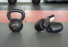 Guantoni da pugile e campana del bollitore sulla stuoia della palestra, exercis di addestramento trasversale immagini stock Guantoni da pugile e campana del bollitore sulla stuoia della palestra, exercis di addestramento trasversale immagini stock