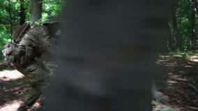 Guerreros parciales de la guerrilla que atacan apuntar en la emboscada del bosque que lleva sus armas El campo de batalla de la g almacen de video Guerreros parciales de la guerrilla que atacan apuntar en la emboscada del bosque que lleva sus armas El campo de batalla de la g almacen de video