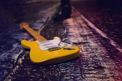 Guitarra amarela elegante no fundo da cidade da noite imagem de stock royalty free Guitarra amarela elegante no fundo da cidade da noite imagem de stock royalty free