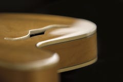 Guitarra do archtop do vintage na opinião de ângulo alto natural do close-up do bordo com detalhe do F-furo no foco seletivo e no foto de stock Guitarra do archtop do vintage na opinião de ângulo alto natural do close-up do bordo com detalhe do F-furo no foco seletivo e no foto de stock