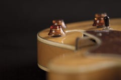 A guitarra do archtop do vintage na opinião de ângulo alto natural do close-up do bordo no fundo preto, controla o detalhe no foc imagem de stock A guitarra do archtop do vintage na opinião de ângulo alto natural do close-up do bordo no fundo preto, controla o detalhe no foc imagem de stock