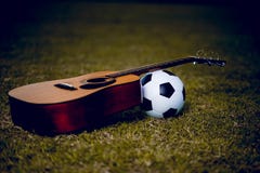 A guitarra e o futebol são colocados em gramados verdes Música e esportes fotos de stock A guitarra e o futebol são colocados em gramados verdes Música e esportes fotos de stock