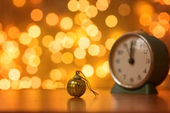 Guld- boll och klocka på bakgrunden av oskarpa ljus royaltyfri fotografi Guld- boll och klocka på bakgrunden av oskarpa ljus royaltyfri fotografi